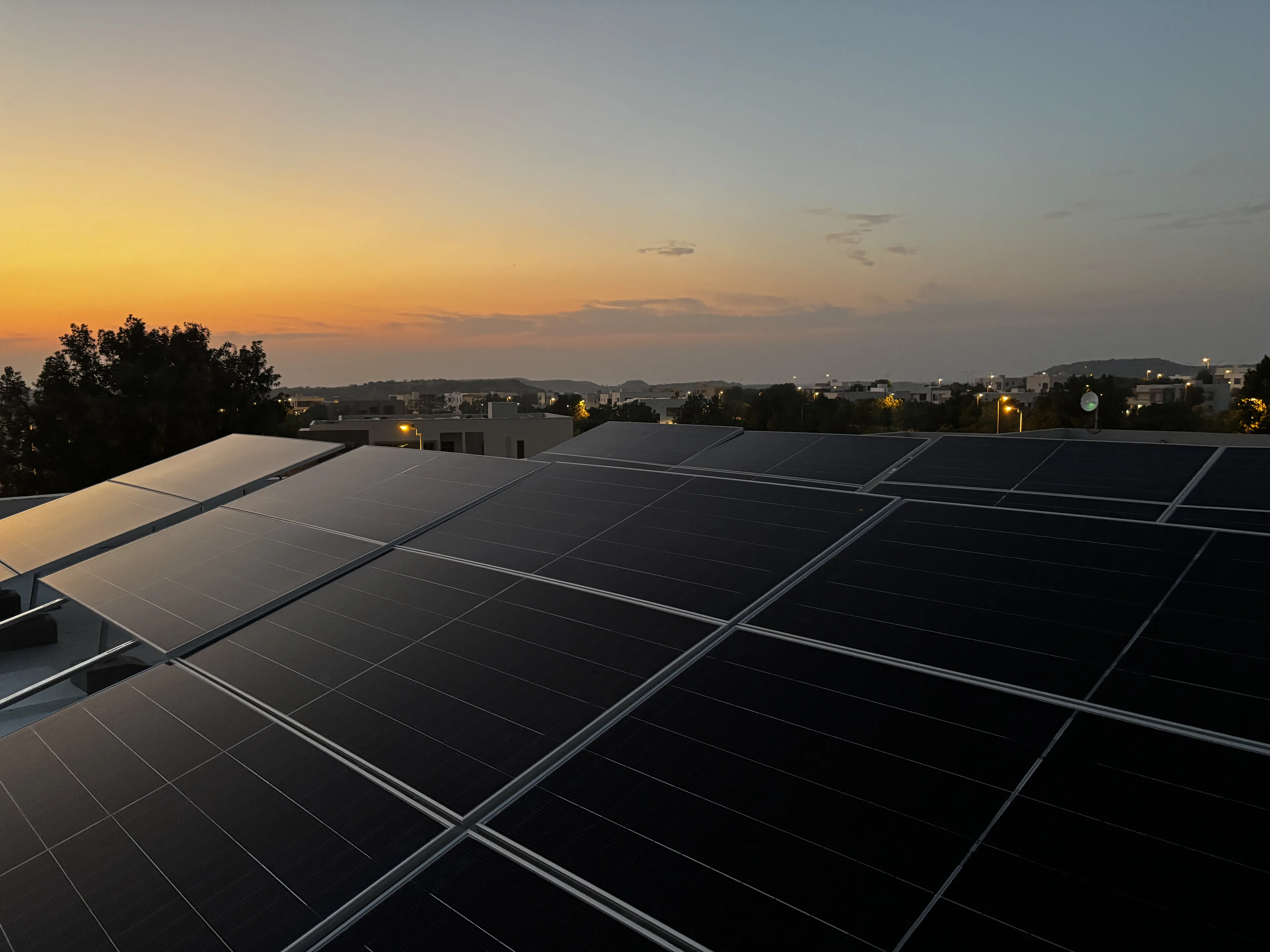 Rooftop solar array installed by APC Solar catching the evening sun over Karachi