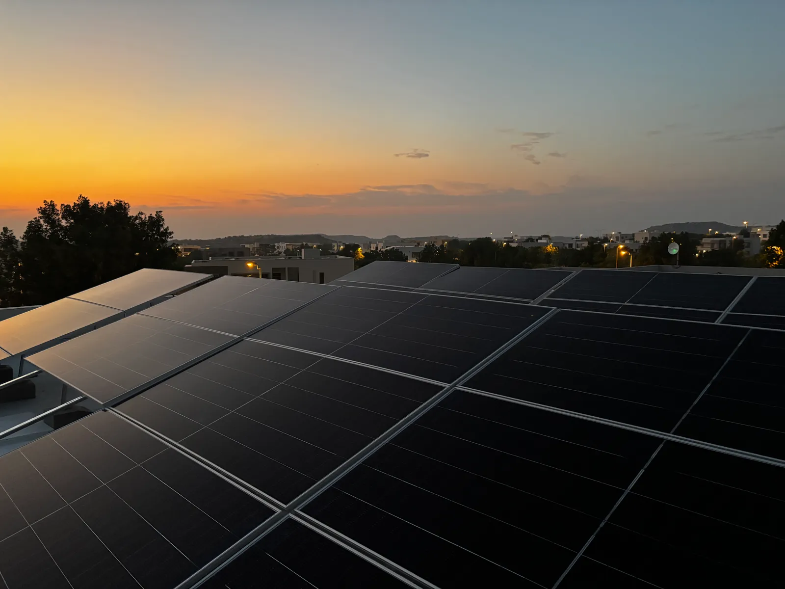 Flush rooftop solar array installed by APC Solar catching the evening sun over Karachi