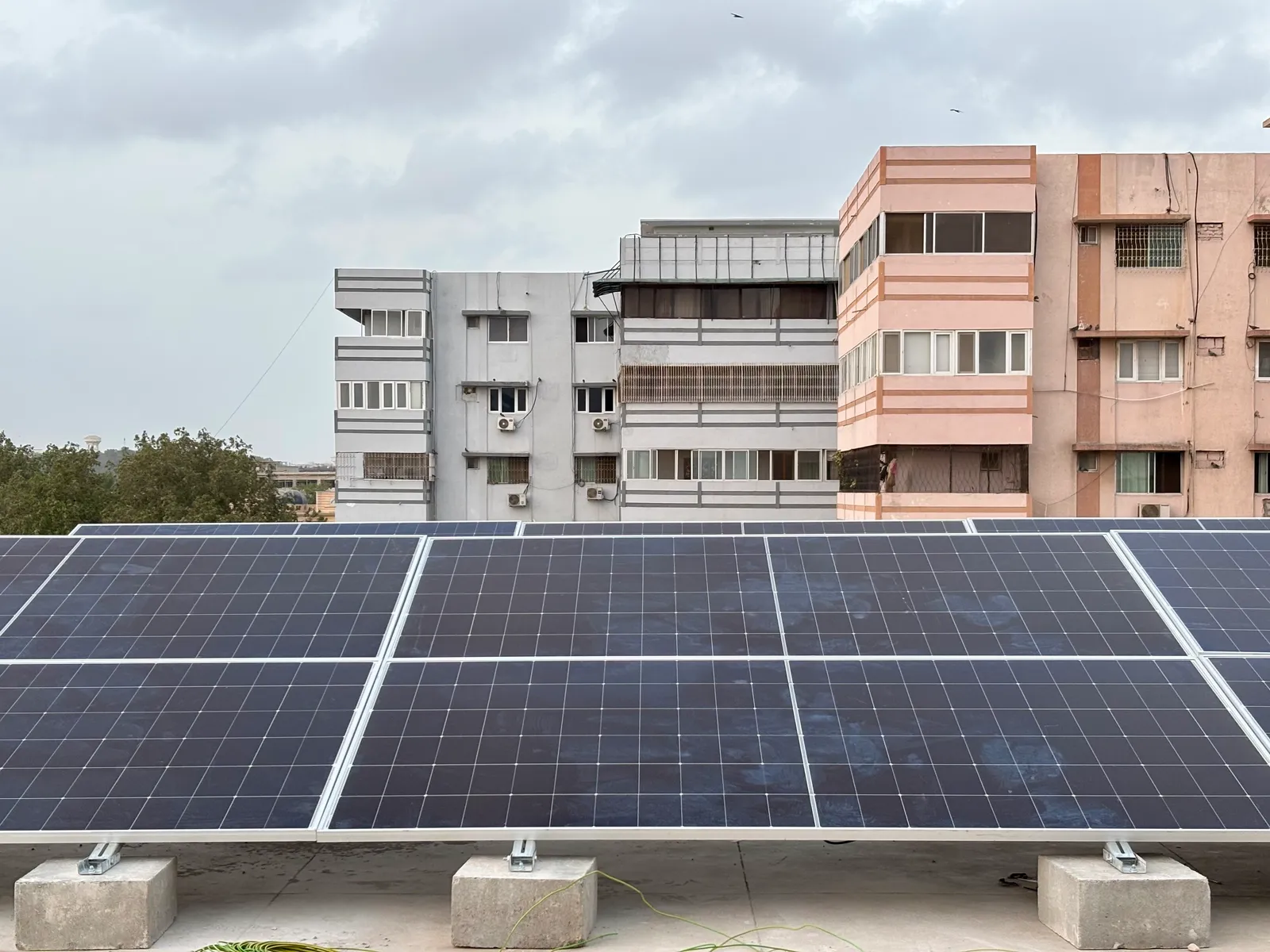 Ground-mounted solar array on concrete ballast blocks installed by APC Solar on a Karachi rooftop